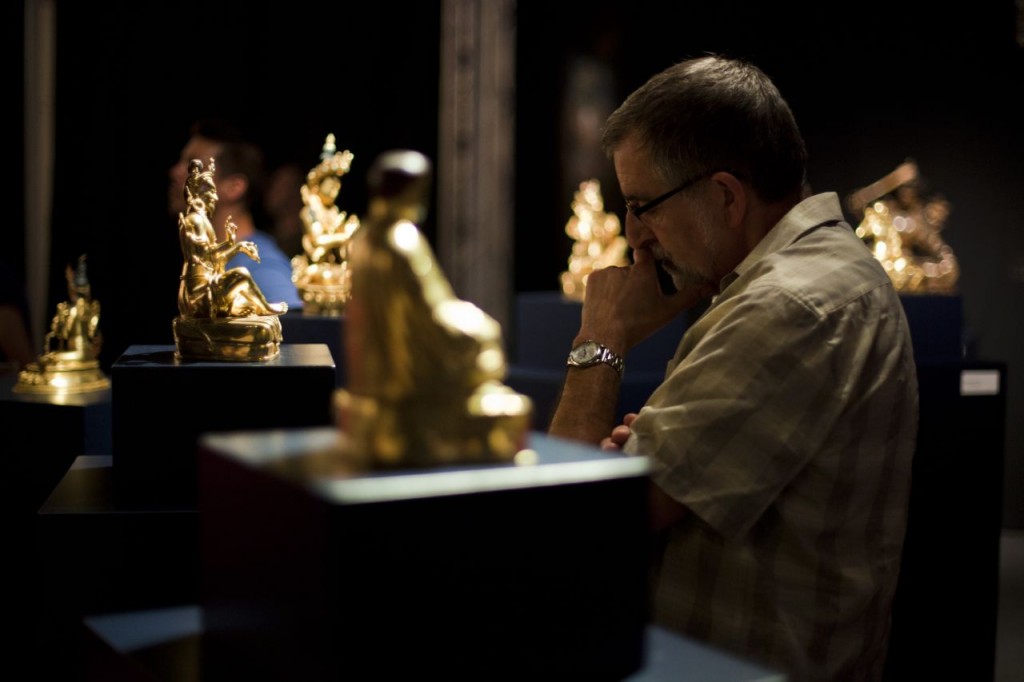 Man interested in Buddha statues at Lambeth exhibition